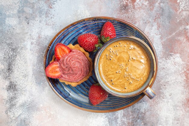 Vista dall'alto tazza di caffè con torta e fragole sul dolce biscotto torta tavolo leggero