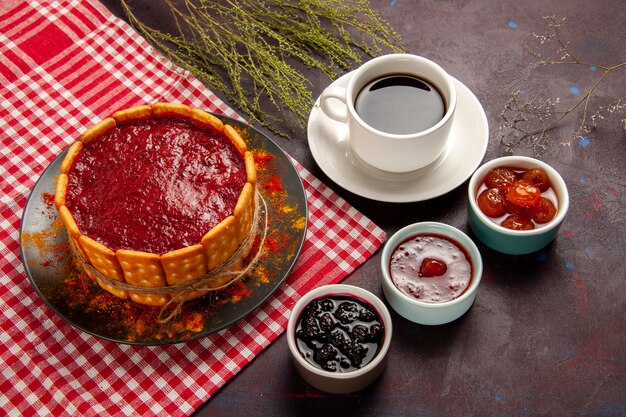 Vista dall'alto tazza di caffè con una deliziosa torta da dessert e marmellate di frutta sulla superficie scura dolce frutta biscotto biscotto dolce