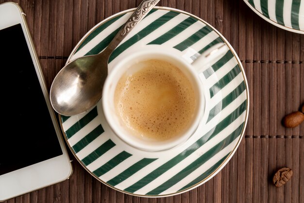 Vista dall'alto tazza di caffè con uno smartphone