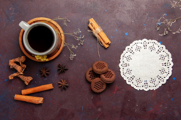 Vista dall'alto tazza di tè all'interno del piatto e tazza su sfondo scuro bevanda del tè foto a colori dolce