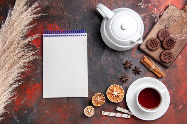 Vista dall'alto tazza di tè con biscotti al cioccolato sul biscotto da tè foto pavimento scuro