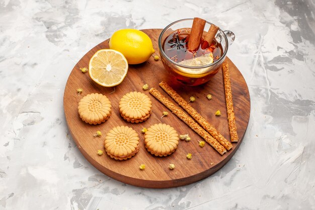 Vista dall'alto tazza di tè con biscotti e limone su uno spazio bianco