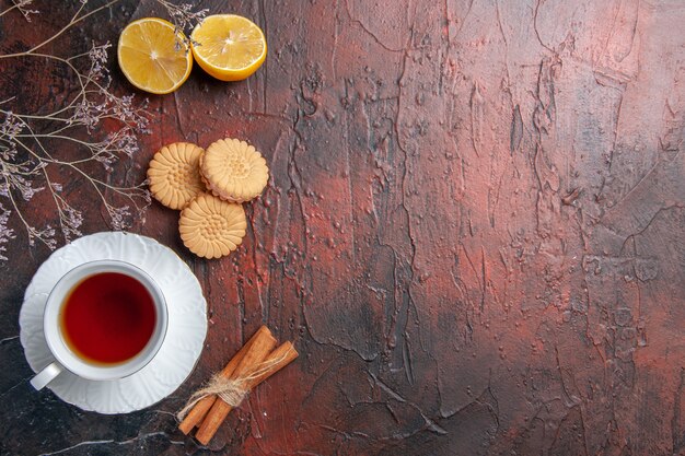 Vista dall'alto tazza di tè con biscotti sul tavolo scuro foto di vetro del tè biscotto dolce