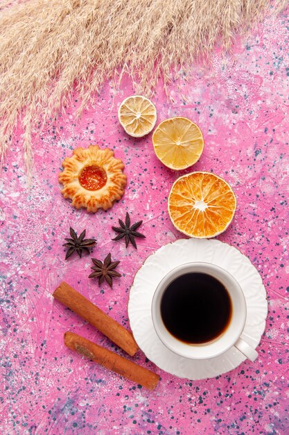 Vista dall'alto tazza di tè con cannella e biscotti su rosa scrivania biscotto biscotto zucchero dolce