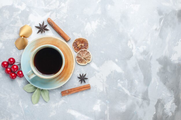Vista dall'alto tazza di tè con cannella sul pavimento bianco tè colore caramella bevanda colazione