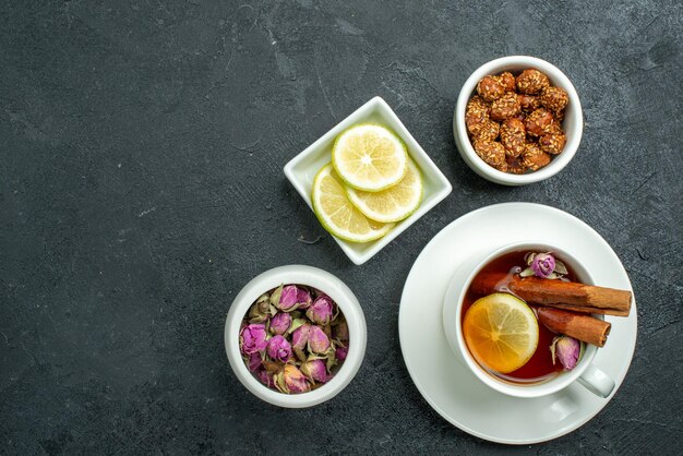 Vista dall'alto tazza di tè con caramelle e tè su cerimonia di agrumi di frutta del tè di superficie scura