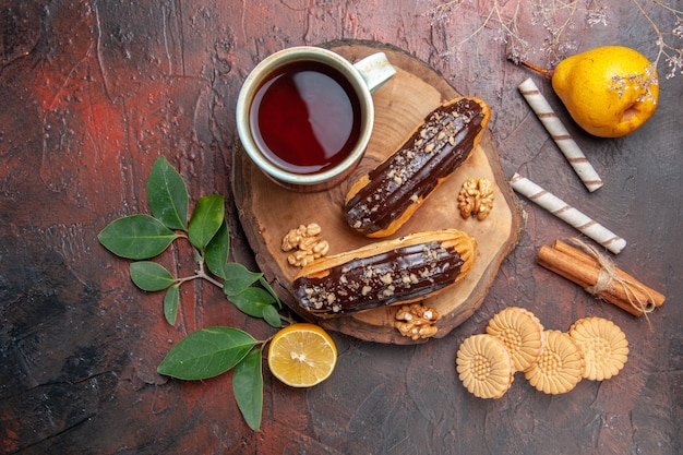 Vista dall'alto tazza di tè con deliziosi bignè al cioccolato sul dessert dolce torta tavolo scuro