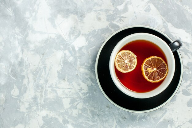 Vista dall'alto tazza di tè con fette di limone sullo sfondo bianco tè bevanda fiori limone