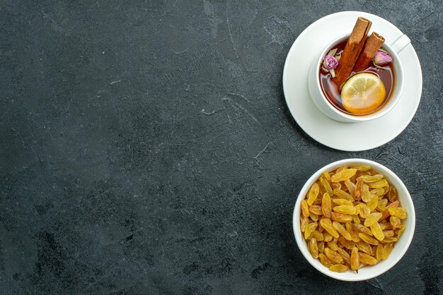 Vista dall'alto tazza di tè con limone e uvetta sulla bevanda cerimonia di frutta tè uvetta superficie scura