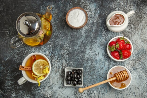 Vista dall'alto tazza di tè con miele e frutta sul tè alla frutta dolce superficie leggera