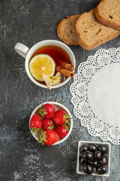 Vista dall'alto tazza di tè con olive e frutta sulla colazione cibo mattina superficie scura