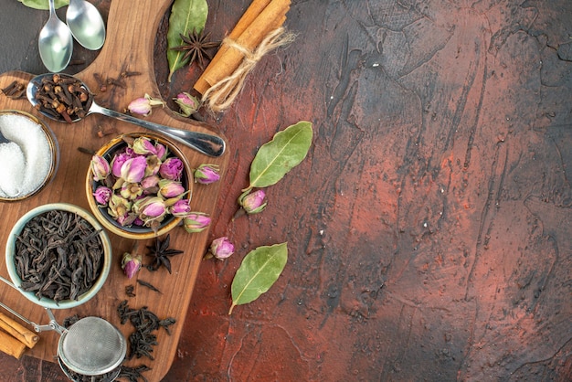 Vista dall'alto tazza di tè con tè nero e fiori secchi su sfondo marrone scuro tè frutta acqua colore cerimonia della colazione foto