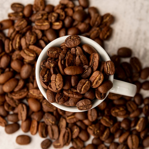 Vista dall'alto tazza piena di chicchi di caffè tostati