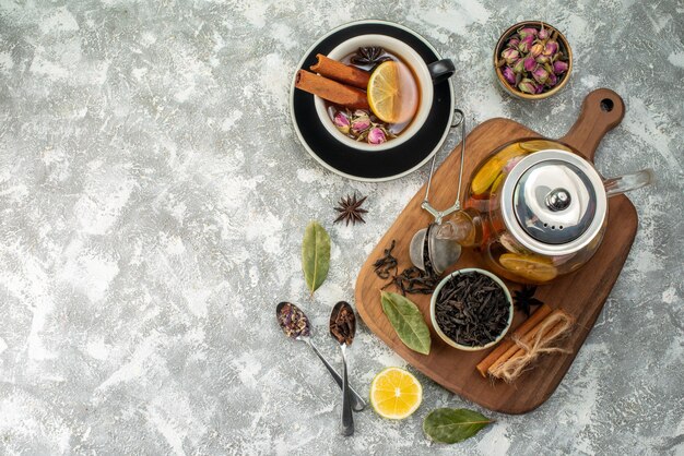 Vista dall'alto tè al limone in tazza e bollitore su sfondo bianco cerimonia dei fiori colore alimentare sapore mattutino colazione alla frutta