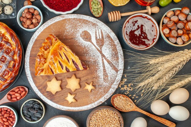 Vista dall'alto torta di frutta gustosa con noci di marmellata e farina sul biscotto scuro torta di dessert torta di tè pasta di zucchero dolce al forno