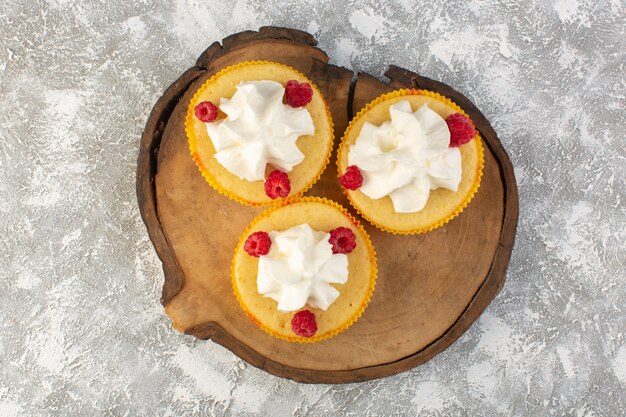 Vista dall'alto torte con crema gustosissima al forno progettate con lampone su sfondo grigio zucchero dolce biscotto crema