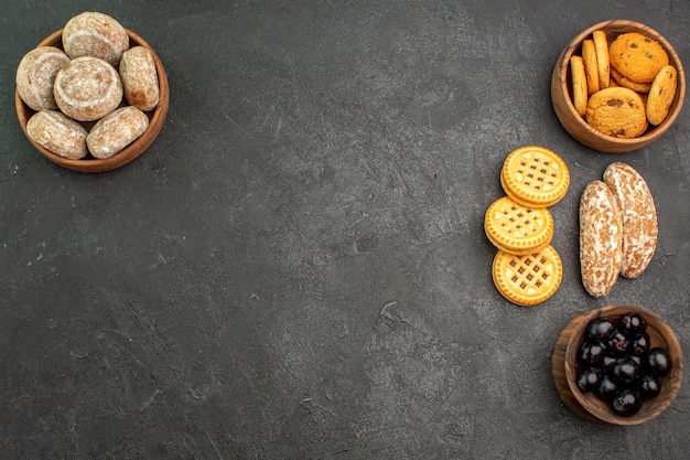 Vista dall'alto torte dolci con biscotti e olive sulla torta torta dolce superficie scura