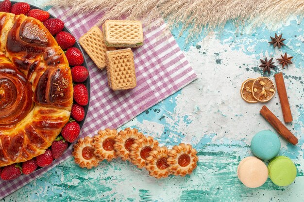 Vista dall'alto una deliziosa torta con fragole rosse e cialde sulla superficie blu