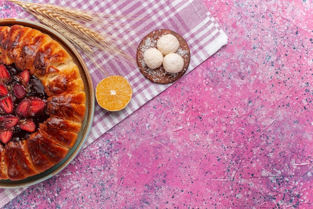 Vista dall'alto una deliziosa torta di fragole tonda formata torta fruttata sul rosa