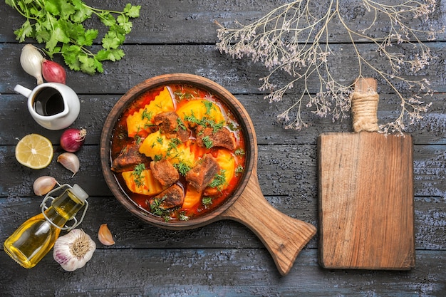 Vista dall'alto una deliziosa zuppa di carne con patate e verdure sulla scrivania scura