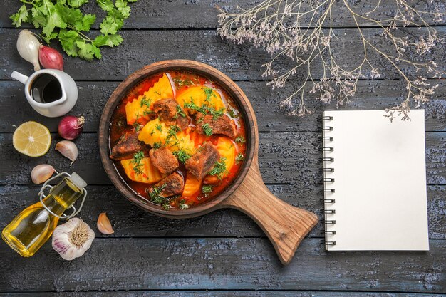 Vista dall'alto una deliziosa zuppa di carne con patate e verdure sulla scrivania scura