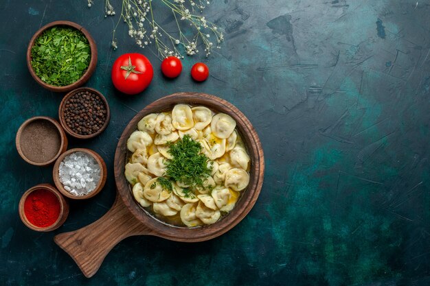 Vista dall'alto una deliziosa zuppa di gnocchi con diversi condimenti sulla zuppa di pasta vegetale di superficie verde