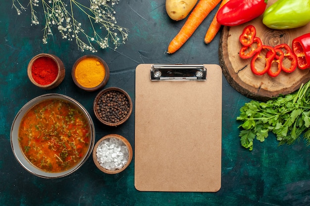 Vista dall'alto una deliziosa zuppa di verdure con condimenti sul pasto di prodotti di zuppa di ingredienti vegetali di superficie verde