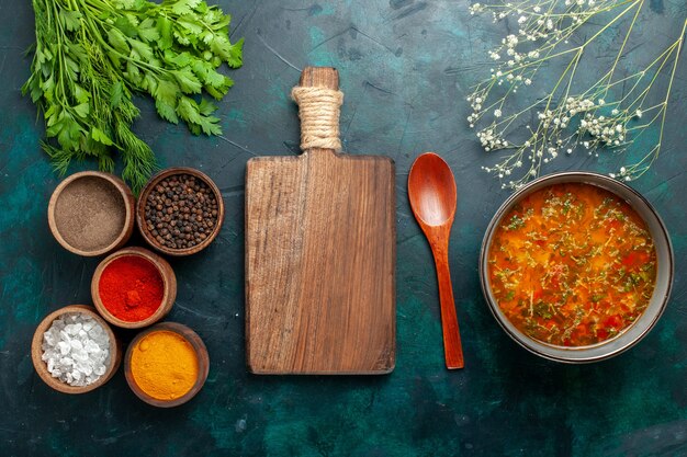 Vista dall'alto una deliziosa zuppa di verdure con diversi condimenti sul prodotto ingrediente della zuppa di verdure del pasto di superficie verde scuro