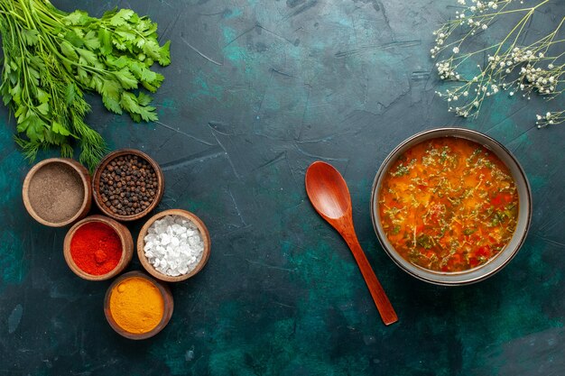 Vista dall'alto una deliziosa zuppa di verdure con diversi condimenti sul prodotto ingrediente di zuppa di verdure di cibo da scrivania verde scuro