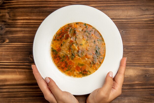 Vista dall'alto una deliziosa zuppa di verdure con verdure sui condimenti vegetali di legno marrone tavolo da minestra alimentare