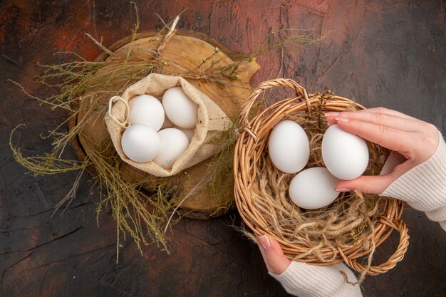 Vista dall'alto uova di gallina all'interno di una piccola borsa e cesto