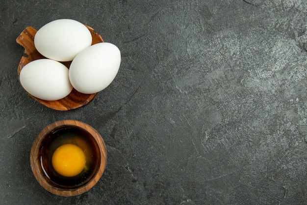 Vista dall'alto uova intere crude su sfondo grigio uovo colazione pasto cibo crudo