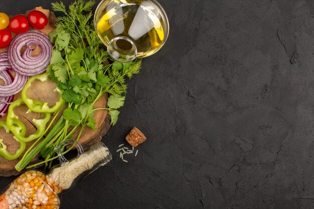 vista dall'alto verdure affettate e fresche come cipolle pomodori e peperoni sullo sfondo grigio