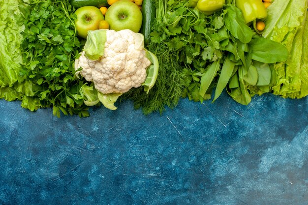 Vista dall'alto verdure e frutta cetriolo prezzemolo aneto peperoni lattuga mele cavolfiore su sfondo blu
