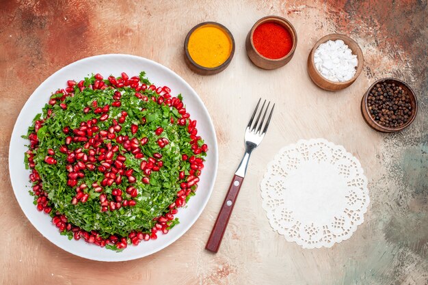 Vista dall'alto verdure fresche con melograni e condimenti su farina di frutta verde da tavola leggera