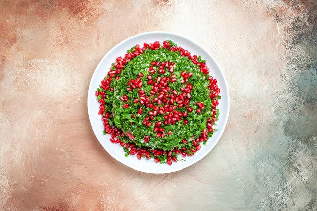 Vista dall'alto verdure fresche con melograni sbucciati sul tavolo luminoso colore verde frutta