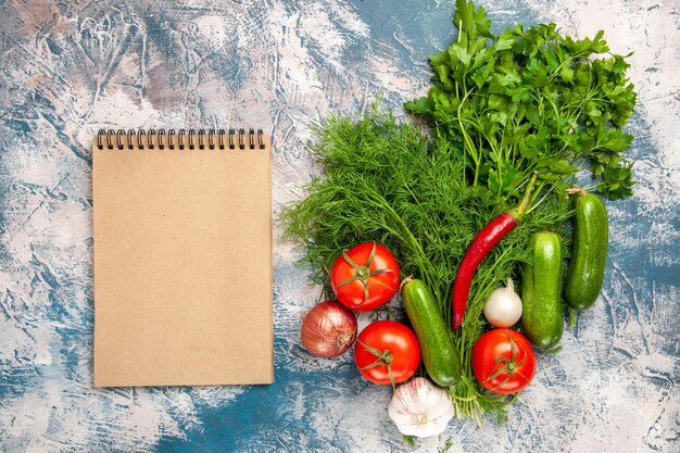 Vista dall'alto verdure fresche con pomodori e cetrioli su sfondo chiaro