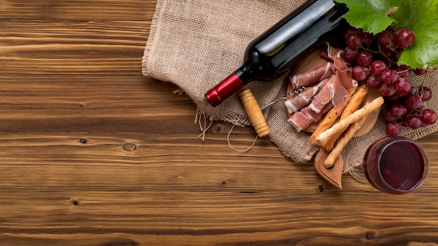 Vista dall&#39;alto vino con cibo e grappolo d&#39;uva