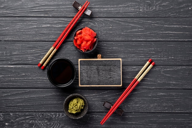 Vista dall'alto wasabi allo zenzero e ciotole di salsa di soia con taccuino in bianco