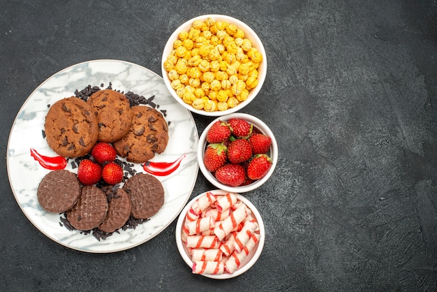 Vista dall'alto yummy choco biscotti con caramelle su sfondo scuro zucchero dolce torta biscotto