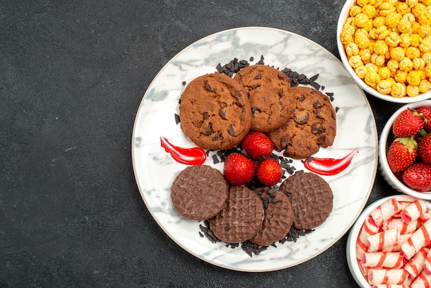 Vista dall'alto yummy choco biscotti con caramelle su sfondo scuro zucchero torta dolce biscotto