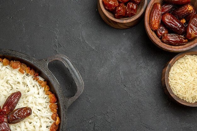 Vista dall'alto yummy plov piatto di riso cotto con uvetta diversa su sfondo scuro piatto di riso all'uvetta cibo olio per cena