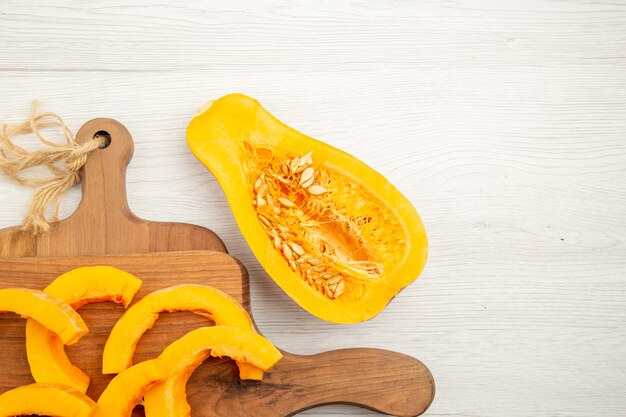 Vista dall'alto zucca tritata su taglieri zucca tagliata a metà sul tavolo grigio