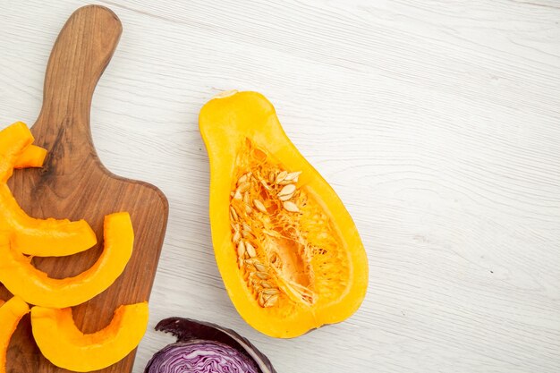 Vista dall'alto zucca tritata sul tagliere zucca tagliata a metà sul tavolo grigio spazio libero