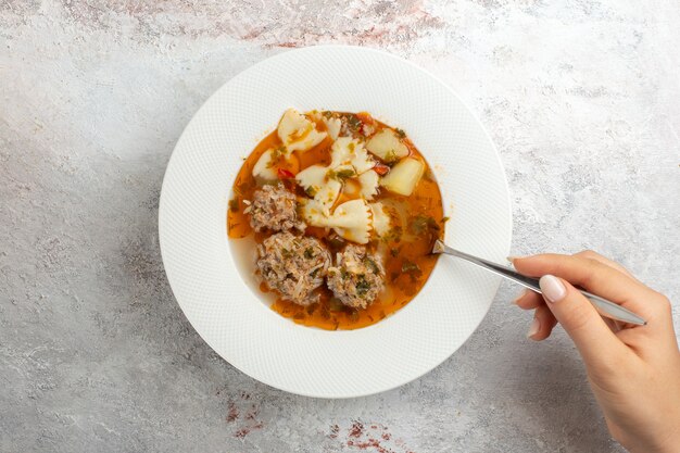 Vista dall'alto zuppa con carne deliziosa zuppa con pasta e carne su sfondo chiaro