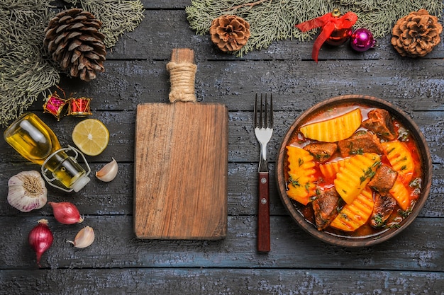 Vista dall'alto zuppa di carne con patate e verdure sulla scrivania blu scuro