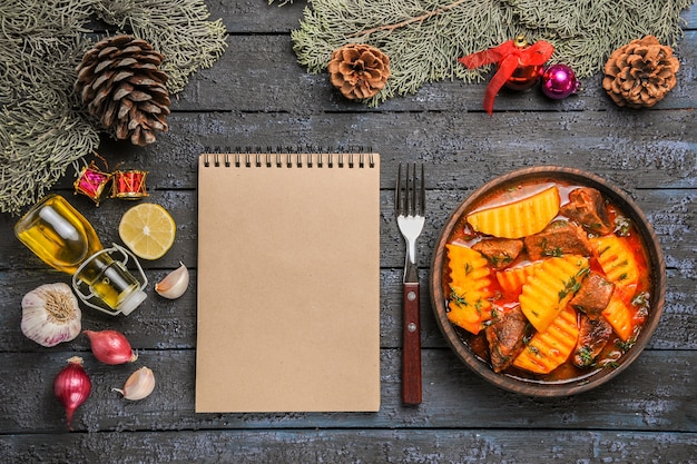 Vista dall'alto zuppa di carne con patate e verdure sulla scrivania scura