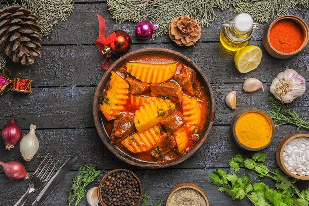 Vista dall'alto zuppa di carne con verdure e patate sul pavimento scuro