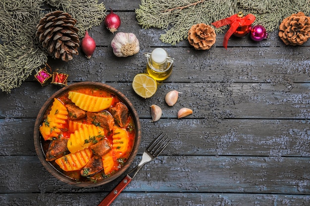 Vista dall'alto zuppa di carne con verdure e patate sulla scrivania buia