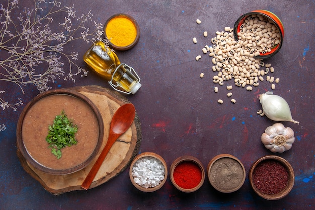 Vista dall'alto zuppa di fagioli deliziosa zuppa cotta con condimenti sul pasto piccante di colore scuro zuppa di fagioli